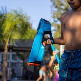 Kid walking with a water gun during an outdoor water game