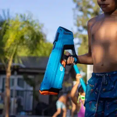 Kid walking with a water gun during an outdoor water game
